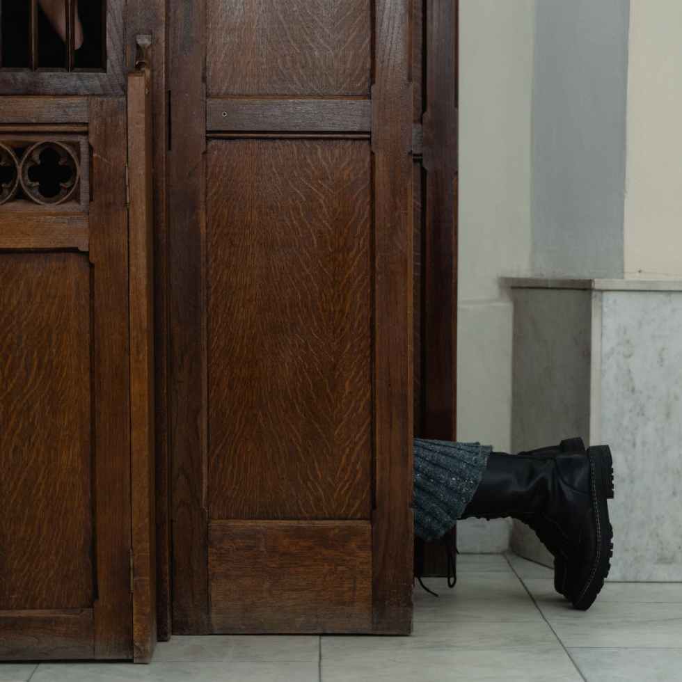 feet of a person kneeling in a confessional
