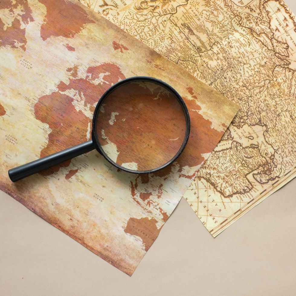 magnifying glass placed on maps